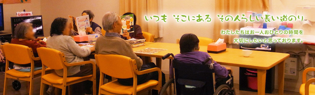 入居者が複数のテーブルで活動する様子。スタッフが見守る中でのレクリエーション風景。